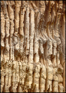 Steinbruchwand in Kenia. Man sieht die runden vertikalen Sägeeinschnitte der Sägeblätter.