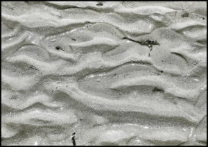 Foto von einem Sandstrand mit gebildeten Wellenbergen im Sand