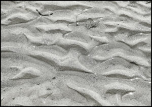 Foto von einem Sandstrand mit gebildeten Wellenbergen im Sand