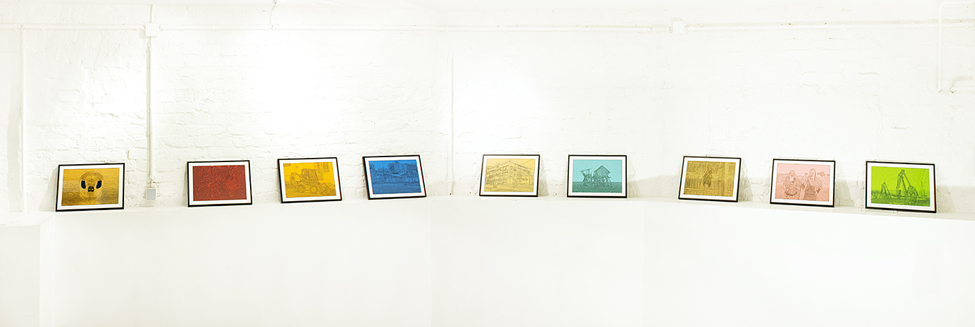 Ausstellungsansicht mehrerer farbiger Zeichnungen in weißgestrichenem Kellerraum