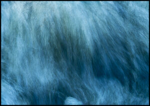 bearbeitete Fotografie von Wasserwellen brechen und stürzen übereinander in Blau